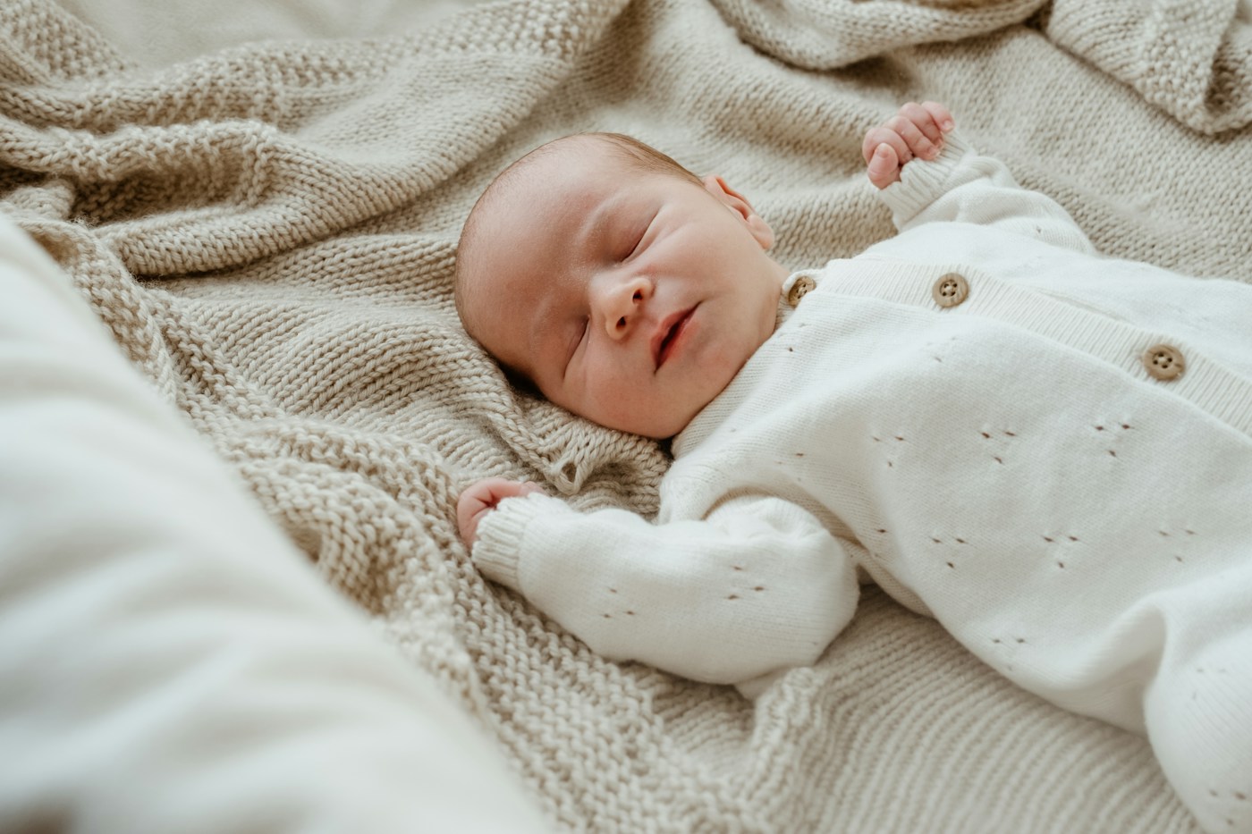 A newborn resting on a soft neutral blanket